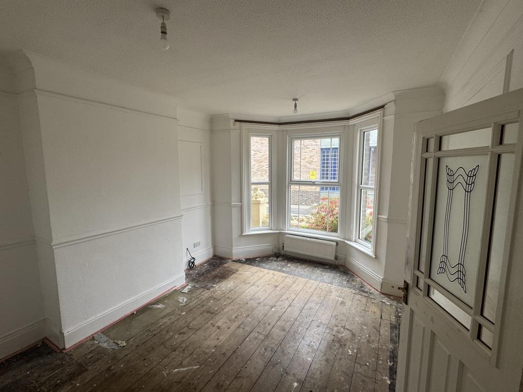 Lot: 80 - FREEHOLD TOWN CENTRE HOUSE COMMERCIAL INVESTMENT AND CAR PARK - Living room with bare floors and white walls